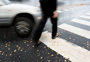 Man on pedestrian crossing in danger of being hit by car