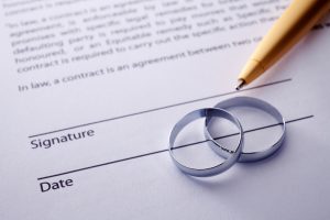 Wedding certificate with two rings and a pen.